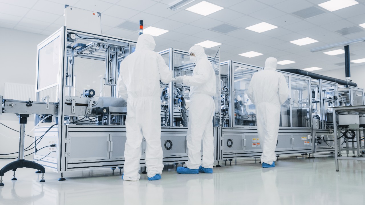 In the Manufacturing Facility Team of Scientist Wearing Sterile Protective Coverall Set's up  Programs Modern Industrial 3D Printer, High Precision Manufacture of Semiconductors under Process.; Shutterstock ID 1268263927; purchase_order: Life Sciences (LS); job: Website Design; client: Brianna Backes (Martech); other: For Andrea Tomovici (LS)